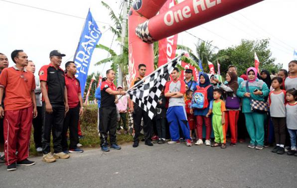Bupati Bangka Mulkan, S.H. M.H. melepas peserta jalan sehat peringatan HUT Ke- 5 Forum Komunikasi Polisi dan Masyarakat (FKPM) Desa Karya Makmur, Minggu (11/11/18). (Foto Humas dan Protoko)